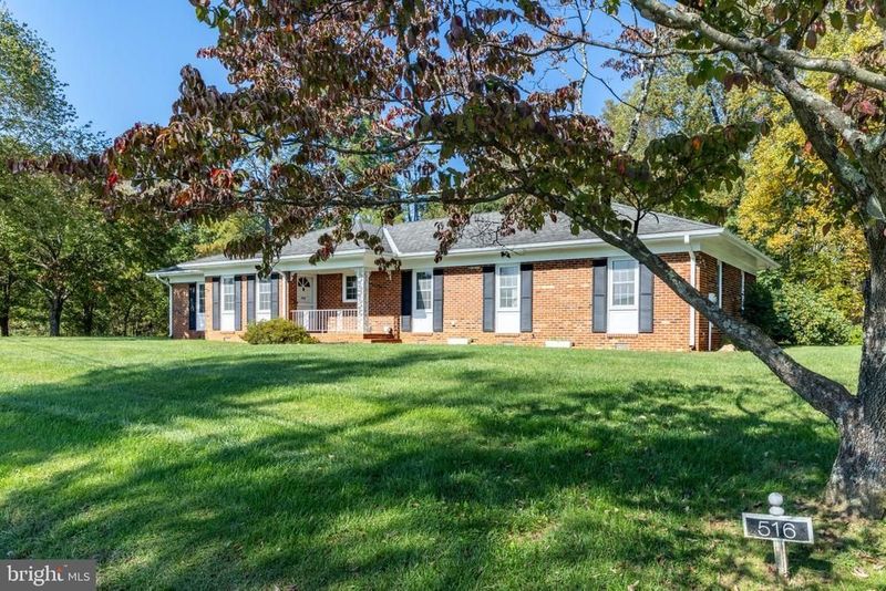 One-story brick home with black shutters and a front porch at 516 Maple Drive, Madison, on a wide green lawn
